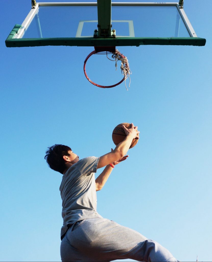 asian basketball player doing a reverse layup